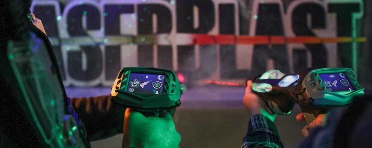 Spelers houden laser guns vast in een neonverlichte lasergame arena
