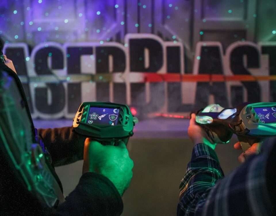 Spelers houden laser guns vast in een neonverlichte lasergame arena